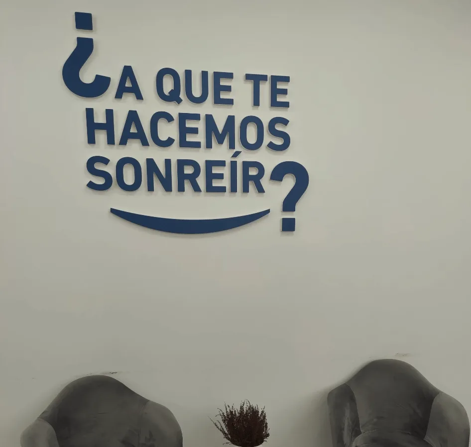 Pared de la clínica con el lema «¿A que te hacemos sonreír?»